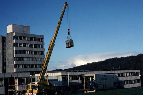 A crane being used to deliver and remove the larger items of equipment. The windows in the stairwell had to be removed to allow a scaffolded platform to be built out at top-floor level in Llandinam