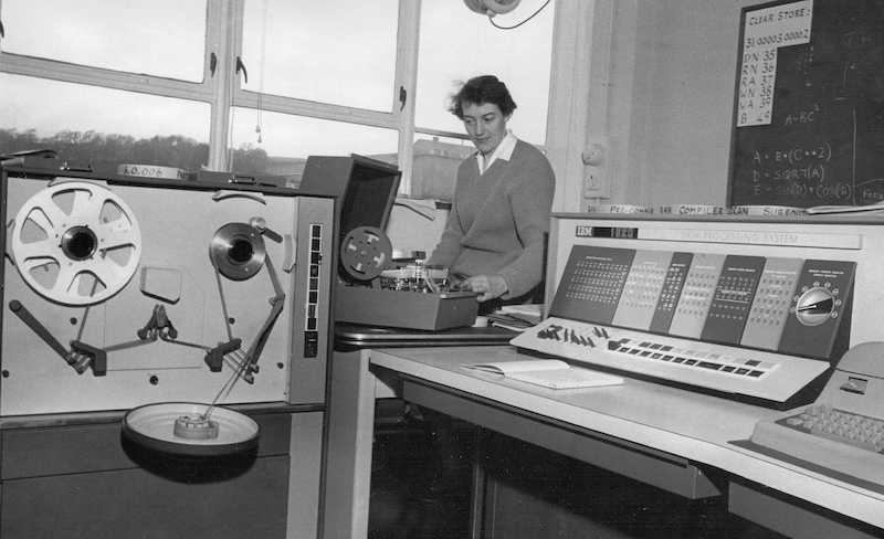 Sylvia Lutkins next to the IBM1620 machine in the Statistics department